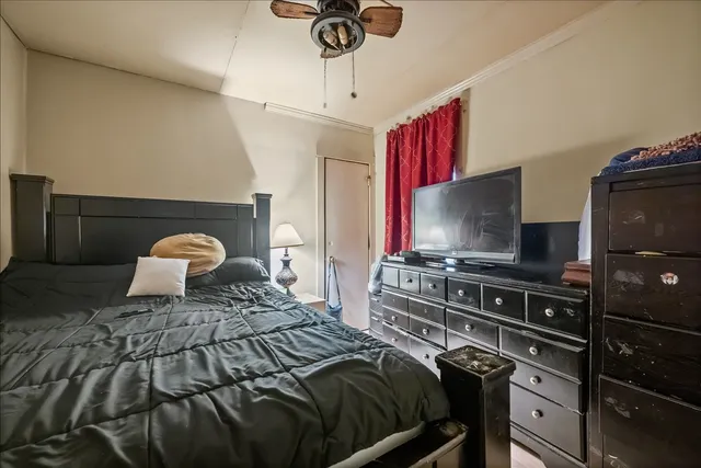 a bedroom with a bed and dresser with wooden floor