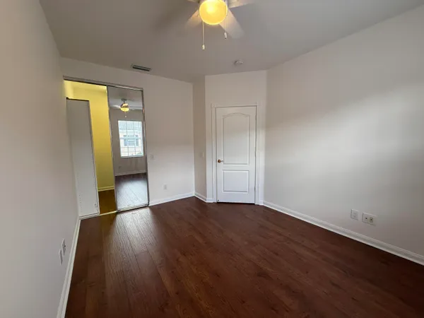 a view of empty room with wooden floor