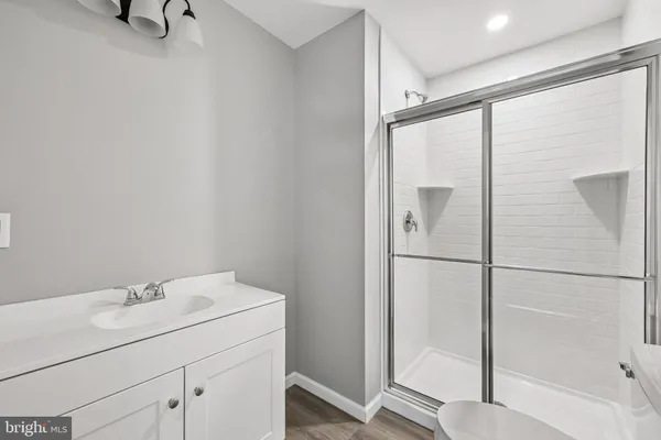 a bathroom with a shower sink and mirror