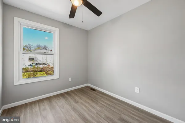 an empty room with wooden floor and window