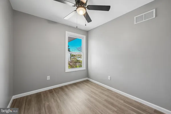 an empty room with a window and a fan