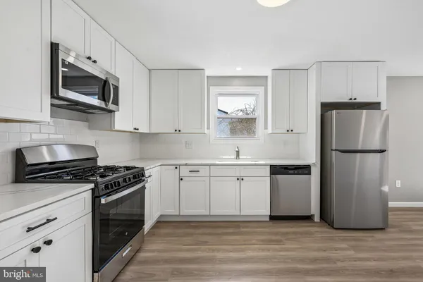 a kitchen with stainless steel appliances granite countertop a refrigerator stove a sink and a microwave