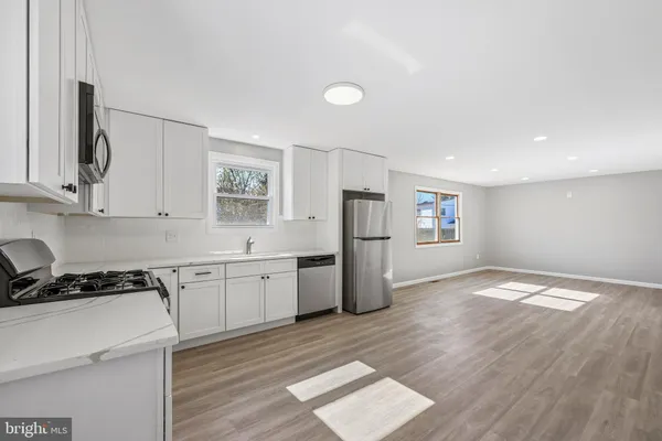 a kitchen with refrigerator cabinets and wooden floor