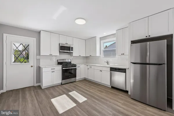 a kitchen with a refrigerator cabinets and wooden floor