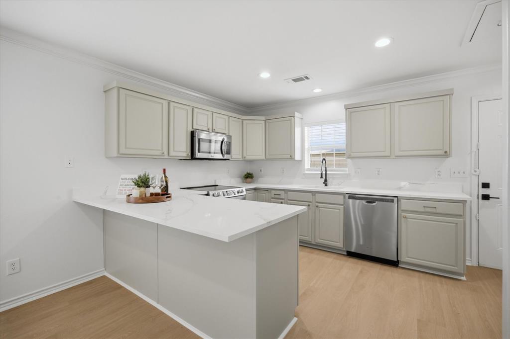 a kitchen with sink a microwave and cabinets