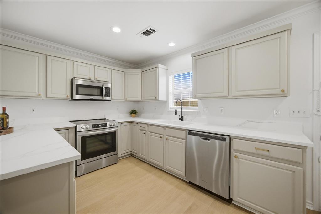 709 Sherman Street Rockwall, TX 75087 - Photo 4 of 23 a kitchen with cabinets appliances a sink and a counter top space