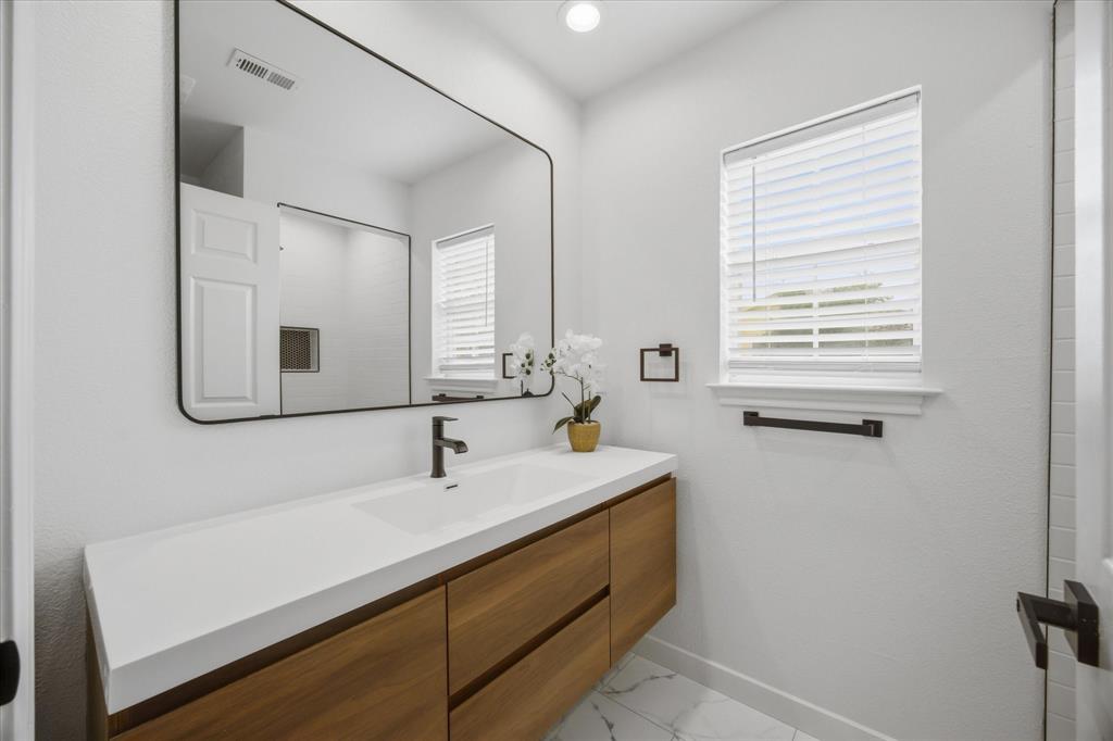 709 Sherman Street Rockwall, TX 75087 - Photo 6 of 23 a bathroom with a sink and a mirror