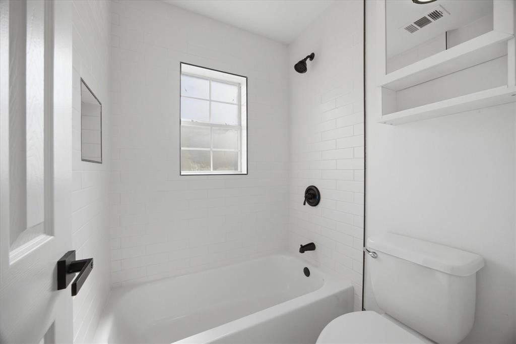 709 Sherman Street Rockwall, TX 75087 - Photo 10 of 23 a bathroom with a shower a toilet and a sink