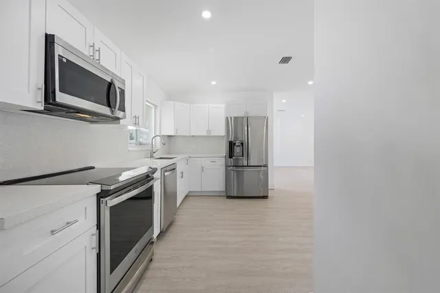 a kitchen with stainless steel appliances a refrigerator stove microwave and sink