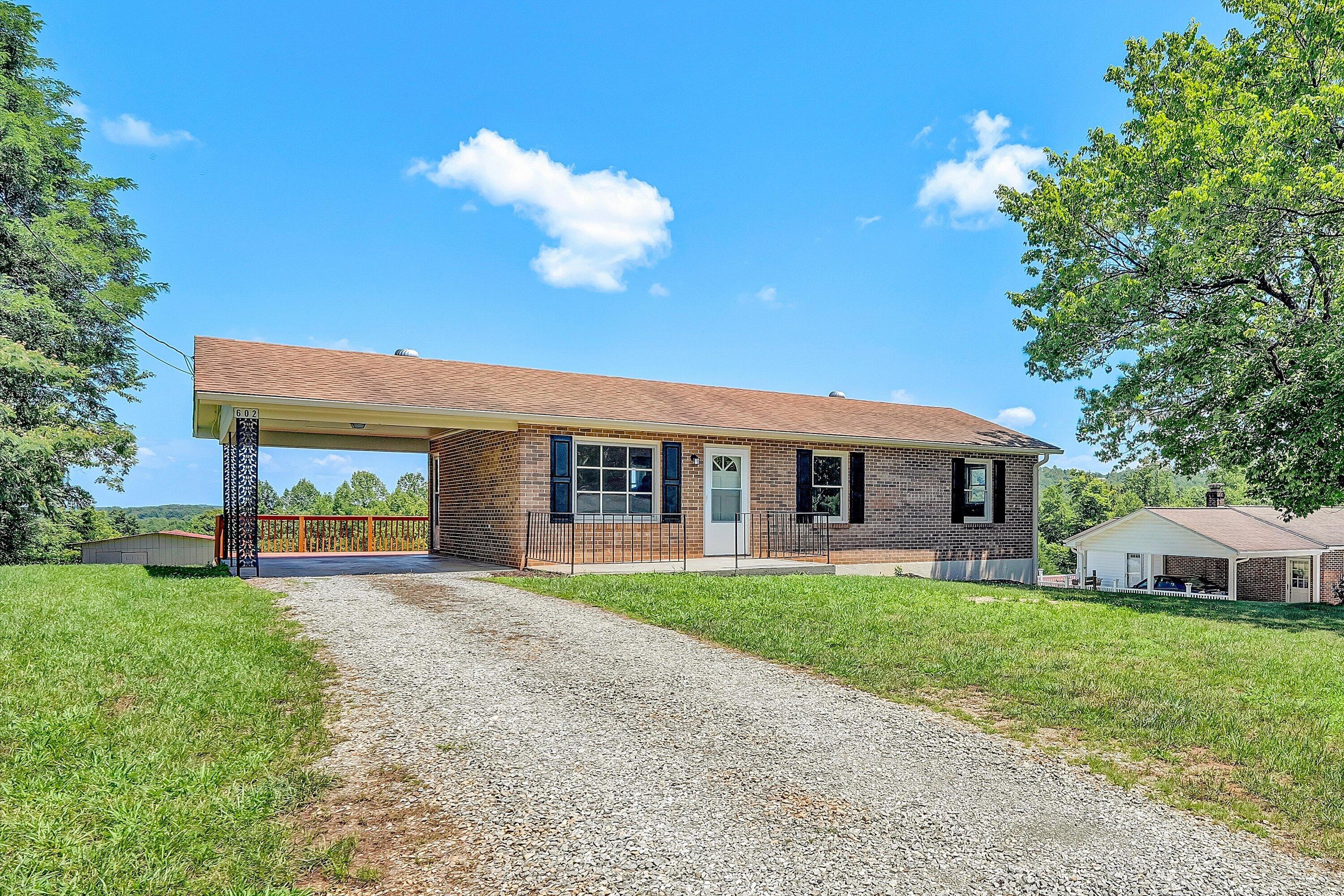 602 Power Dam Road Rocky Mount, VA 24151 - Photo 29 of 34 a front view of a house with a garden and yard