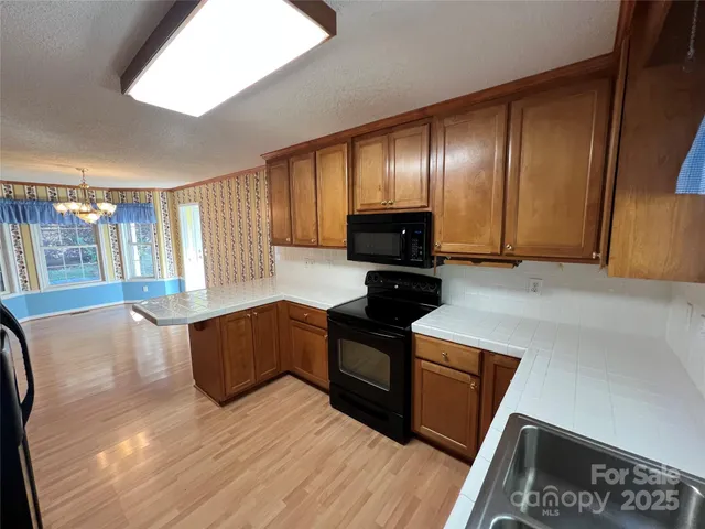 a kitchen with granite countertop a stove top oven and cabinets