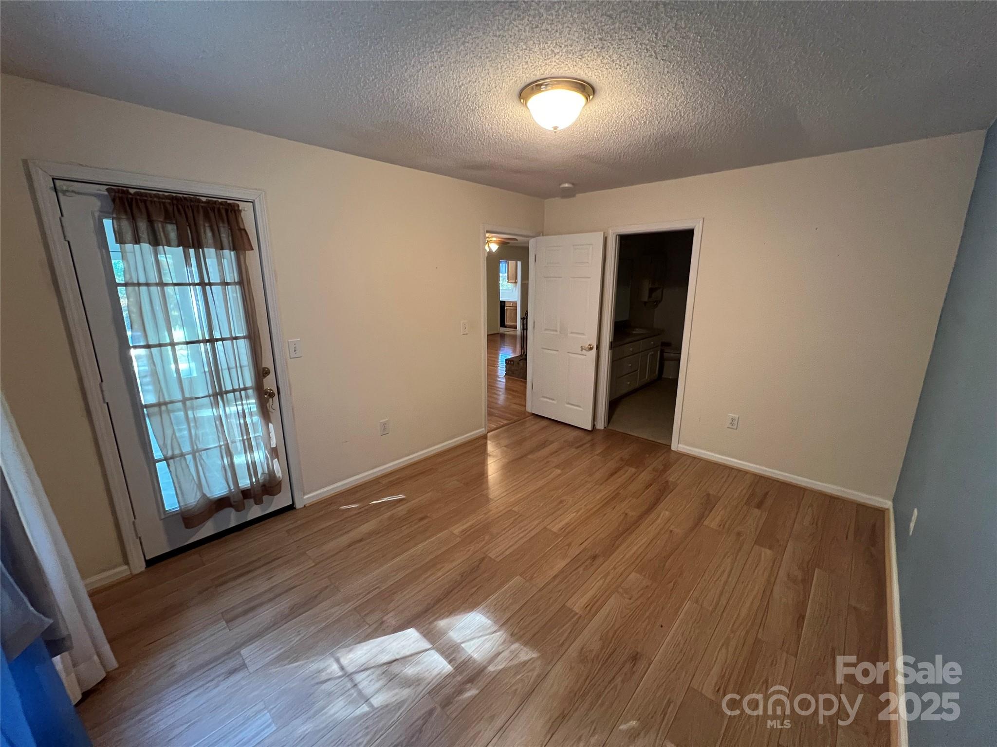 25397 Stony Mountain Road Albemarle, NC 28001 - Photo 19 of 32 an empty room with wooden floor and windows