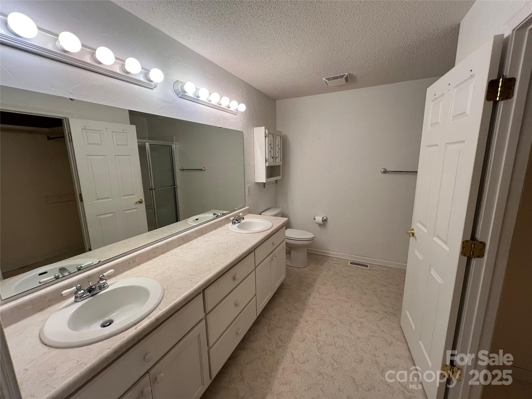 25397 Stony Mountain Road Albemarle, NC 28001 - Photo 21 of 32 a bathroom with a double vanity sink and mirror