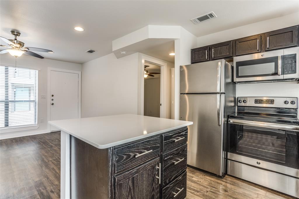 2106 Bennett Avenue, Unit 209 Dallas, TX 75206 - Photo 10 of 22 Kitchen island with a white countertop and dark wood-finish cabinetry