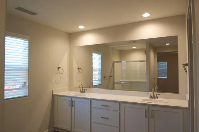 a bathroom with a double vanity sink and a mirror