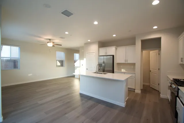 a view of kitchen with cabinets stainless steel appliances and wooden floor