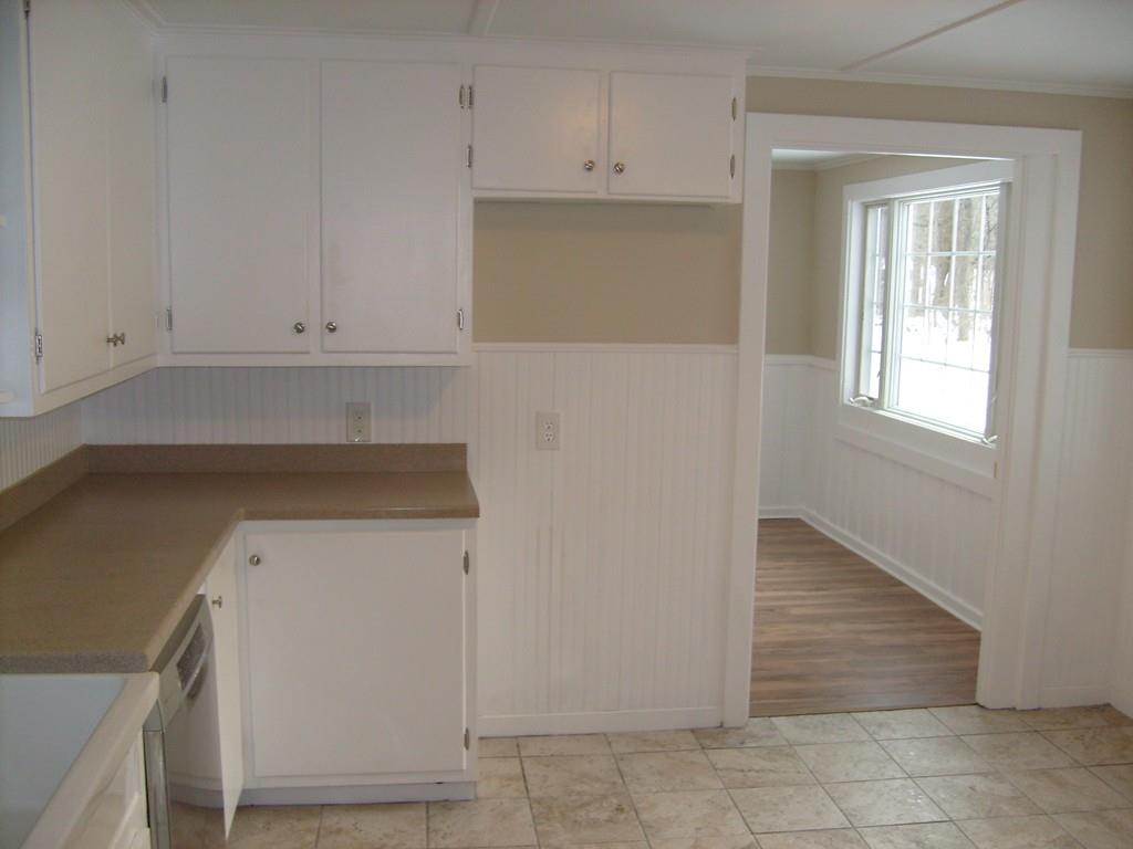 49 Birch Meadow Road Merrimac, MA 01860 - Photo 8 of 27 a kitchen with white cabinets and a window