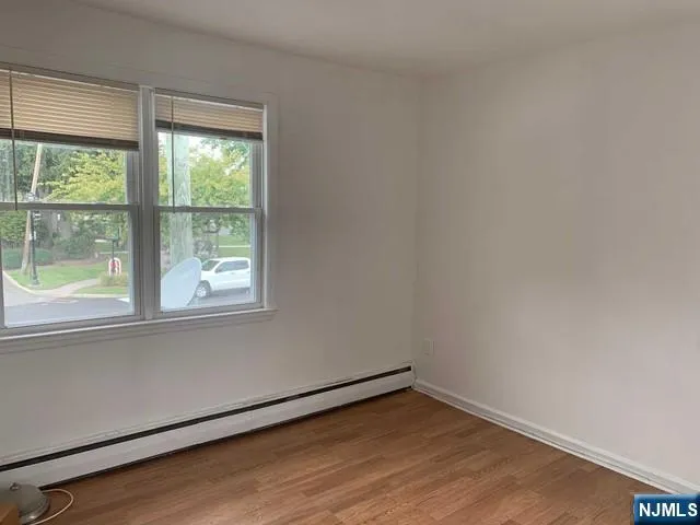 a view of a room with wooden floor and a window