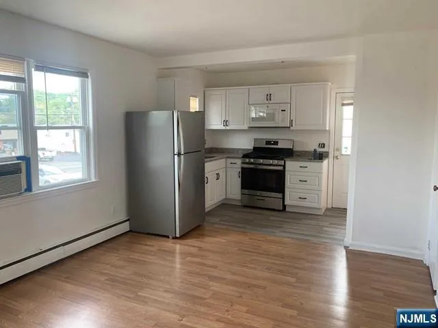 a kitchen with stainless steel appliances granite countertop a refrigerator stove and wooden floor