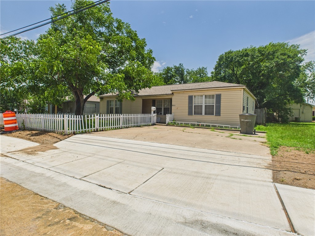Ranch-style house with a fenced front yard and driveway