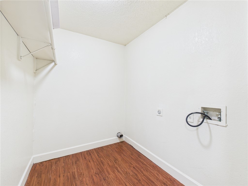 2702 Cavitt Avenue Bryan, TX 77801 - Photo 13 of 21 Laundry area featuring dark wood-type flooring, hookup for a washing machine, a textured ceiling, and electric dryer hookup