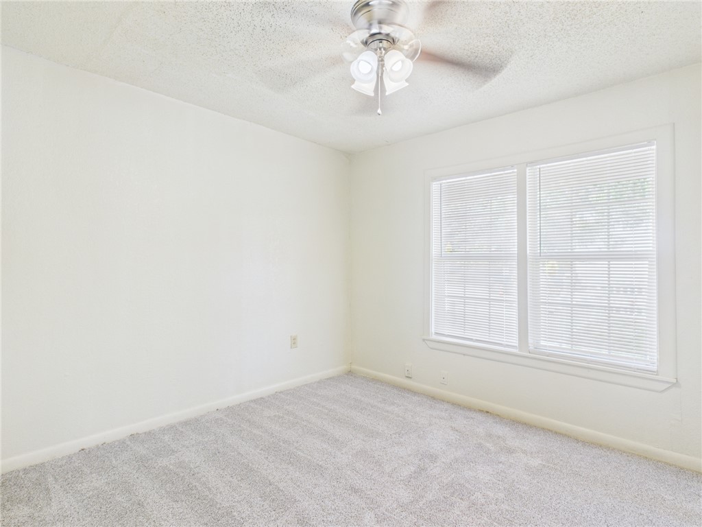 2702 Cavitt Avenue Bryan, TX 77801 - Photo 15 of 21 Empty room featuring a textured ceiling, a ceiling fan, and carpet floors