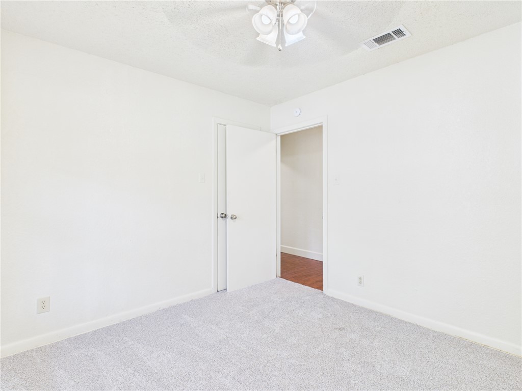 2702 Cavitt Avenue Bryan, TX 77801 - Photo 16 of 21 Carpeted spare room featuring a textured ceiling and a ceiling fan