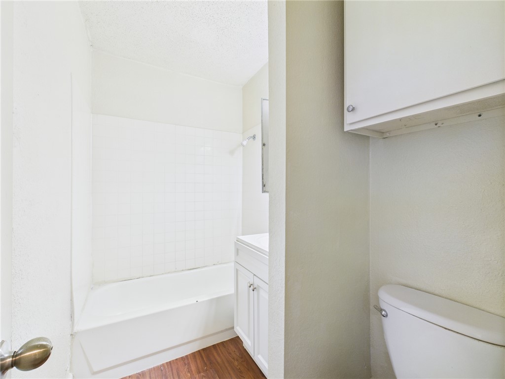 2702 Cavitt Avenue Bryan, TX 77801 - Photo 17 of 21 Bathroom with shower / bathtub combination, vanity, a textured ceiling, and dark wood-style flooring