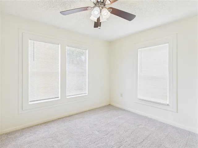an empty room with closet and a chandelier fan