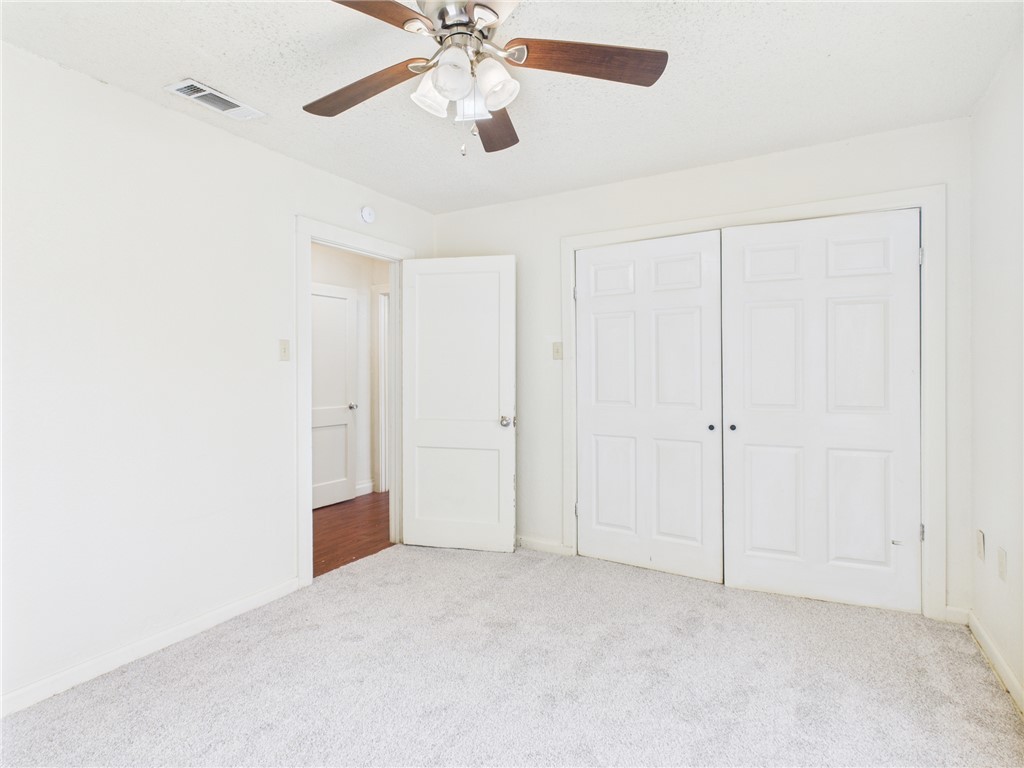 2702 Cavitt Avenue Bryan, TX 77801 - Photo 19 of 21 Unfurnished bedroom with carpet floors, ceiling fan, a closet, and a textured ceiling