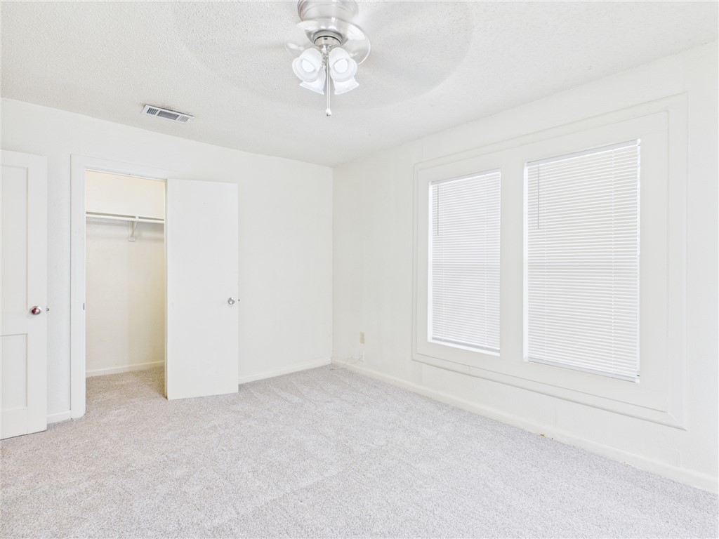 2702 Cavitt Avenue Bryan, TX 77801 - Photo 21 of 21 Unfurnished bedroom with light colored carpet, a textured ceiling, and a ceiling fan