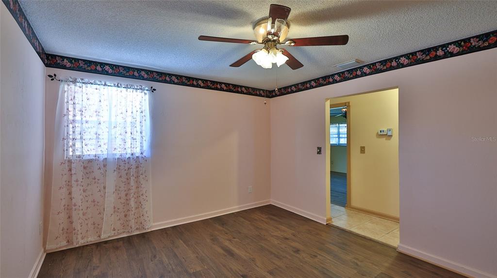 725 Green Road New Smyrna Beach, FL 32168 - Photo 19 of 40 a view of an empty room with a window and wooden floor