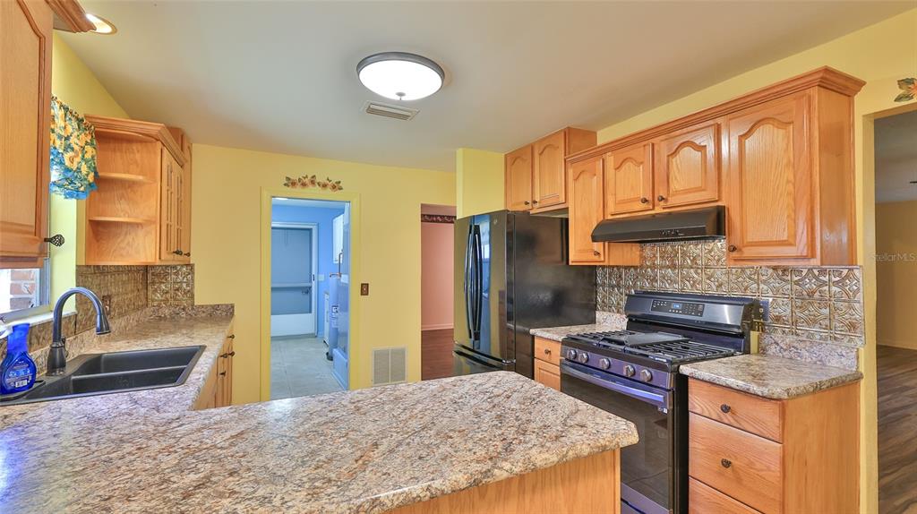 725 Green Road New Smyrna Beach, FL 32168 - Photo 24 of 40 a kitchen with stainless steel appliances granite countertop a stove refrigerator and cabinets