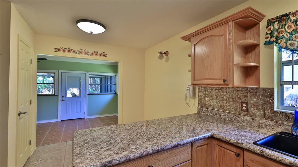 725 Green Road New Smyrna Beach, FL 32168 - Photo 25 of 40 a kitchen with stainless steel appliances granite countertop a stove and cabinets