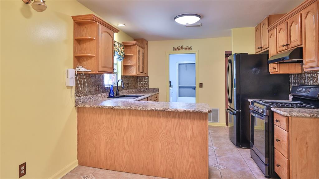 725 Green Road New Smyrna Beach, FL 32168 - Photo 26 of 40 a kitchen with stainless steel appliances granite countertop a sink stove and refrigerator