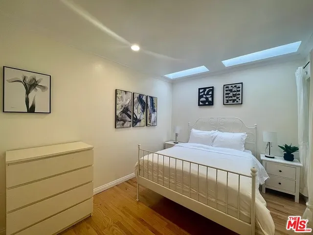 a bedroom with a bed and painting on the wall