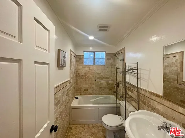 a bathroom with a bathtub toilet and a shower