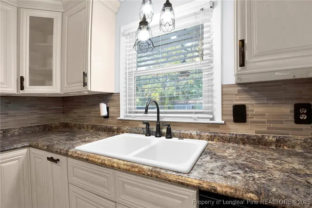 a kitchen with granite countertop sink and cabinets