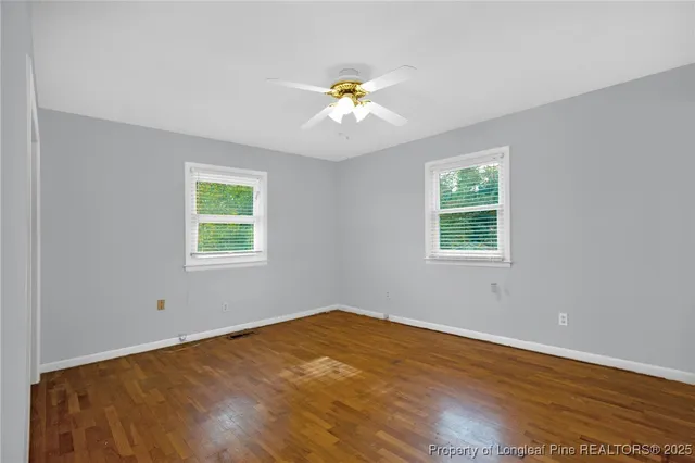 an empty room with a window and ceiling fan