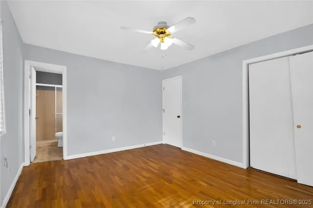 a view of a bedroom with a bed and a ceiling fan