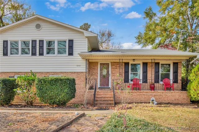 front view of a brick house with a yard