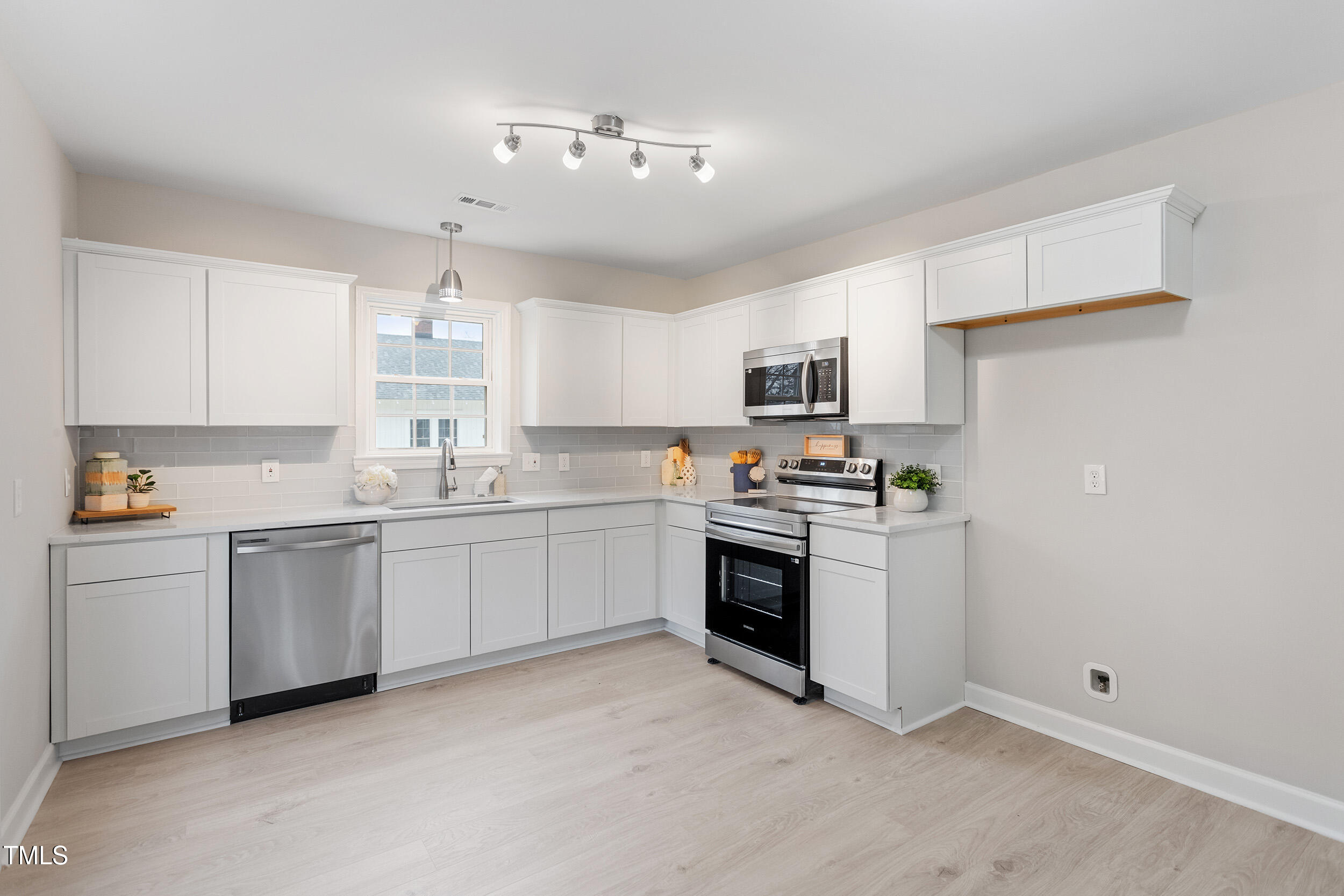 6215 Pine Street Bailey, NC 27807 - Photo 7 of 24 a kitchen with granite countertop white cabinets and stainless steel appliances
