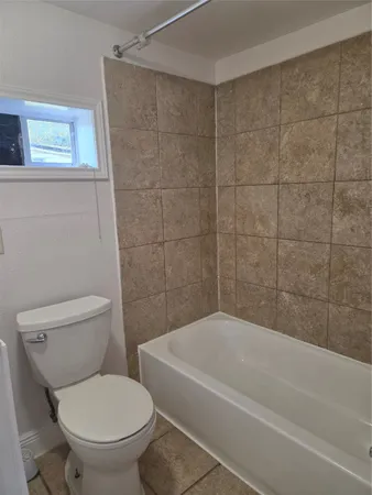a bathroom with a toilet and a bath tub