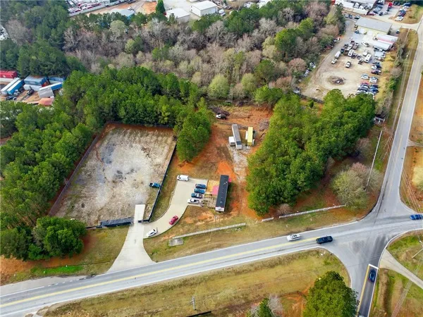 an aerial view of a house with swimming pool and large trees