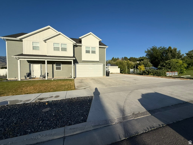 1886 North 300 West Logan, UT 84341 - Photo 2 of 18 Two-story residence featuring light gray siding and white vertical board-and-batten accents