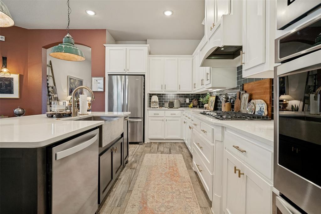 14948 Gentry Drive Aledo, TX 76008 - Photo 12 of 25 Kitchen featuring an integrated stainless steel refrigerator, built-in wall oven, gas cooktop, and a farm sink in the island with a stainless steel dishwasher