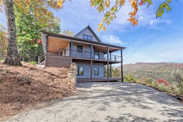 a view of a house with a yard and large tree