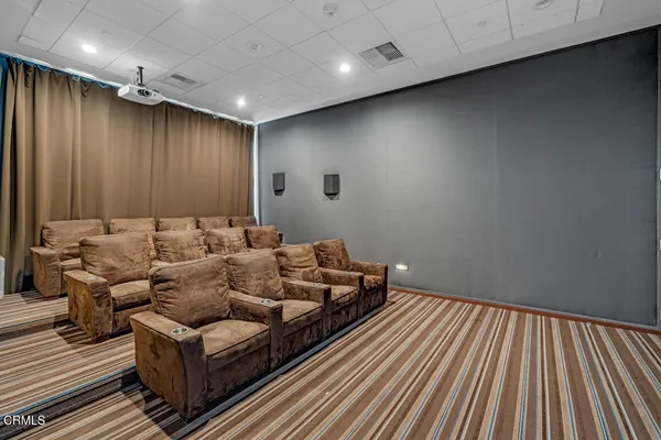a media room with lots of chairs and wooden floor