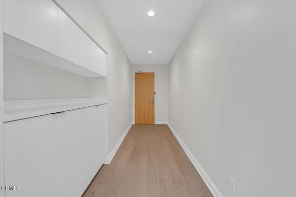 an empty room with kitchen and windows
