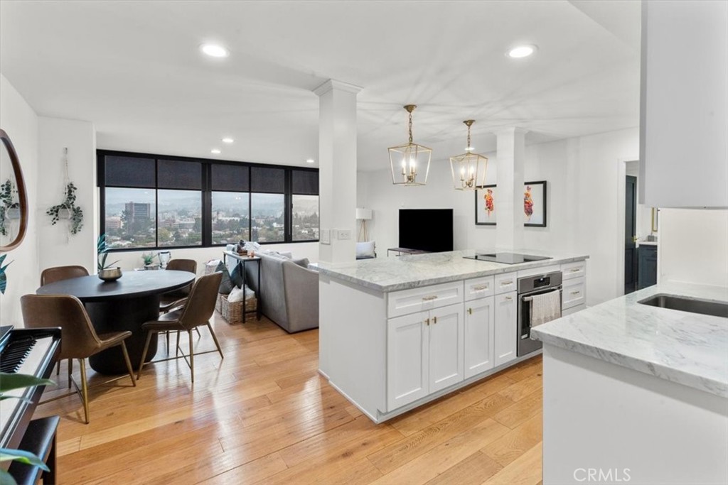 10501 Wilshire Boulevard, Unit 2212 Los Angeles, CA 90024 - Photo 4 of 25 a kitchen with a stove a sink a dining table and chairs
